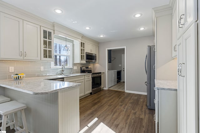 kitchen featuring tasteful backsplash, sink, dark hardwood / wood-style flooring, a kitchen bar, and stainless steel appliances