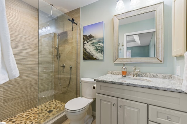 bathroom featuring vanity, a shower with shower door, and toilet