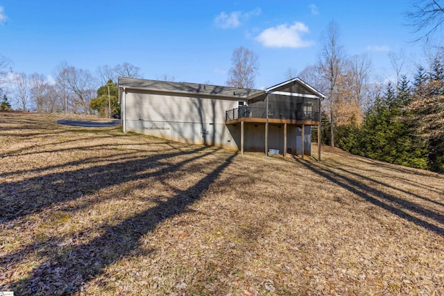 rear view of house with a sunroom, a yard, and a deck