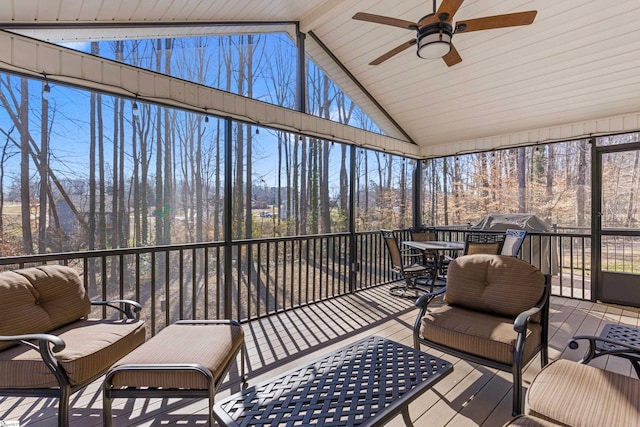 sunroom / solarium featuring ceiling fan and lofted ceiling with beams