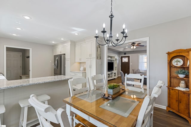 dining room with dark wood-type flooring and ceiling fan with notable chandelier