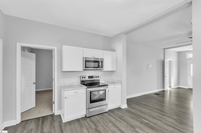 kitchen with stainless steel appliances, wood-type flooring, light stone countertops, and white cabinets