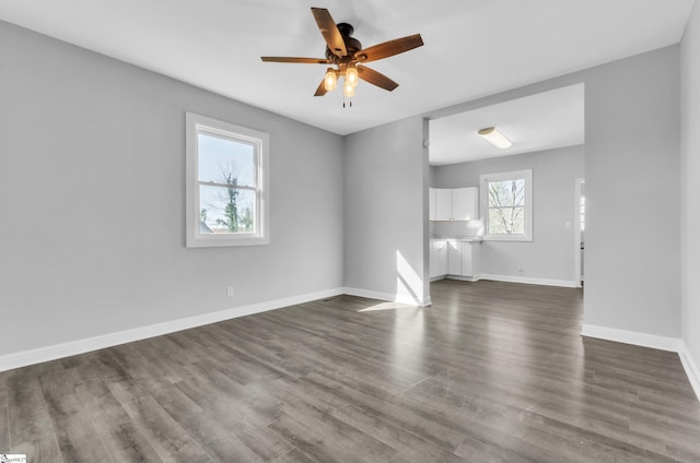 unfurnished living room with dark wood-type flooring and ceiling fan