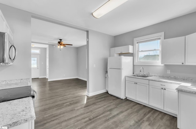 kitchen featuring white cabinetry, a healthy amount of sunlight, sink, and white fridge