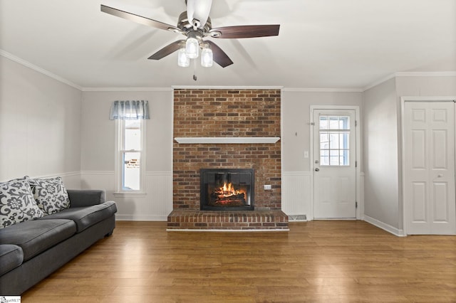 living room with a fireplace, wood-type flooring, and plenty of natural light