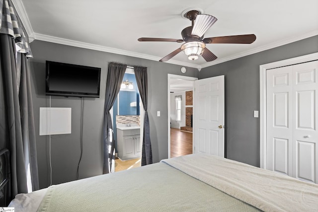 bedroom with sink, ornamental molding, a closet, and ceiling fan