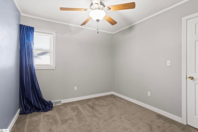 carpeted spare room with crown molding and ceiling fan