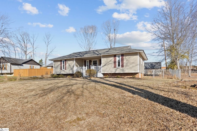 ranch-style house featuring covered porch and a front lawn