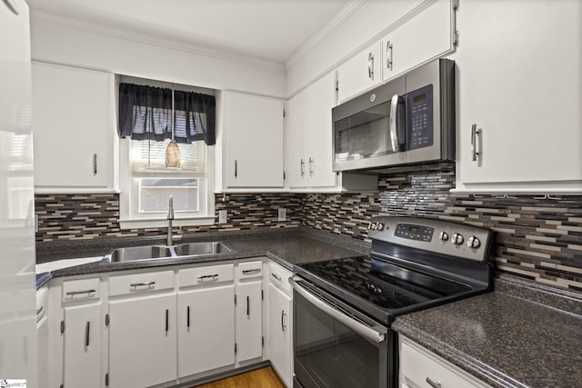 kitchen featuring tasteful backsplash, white cabinetry, sink, ornamental molding, and stainless steel appliances