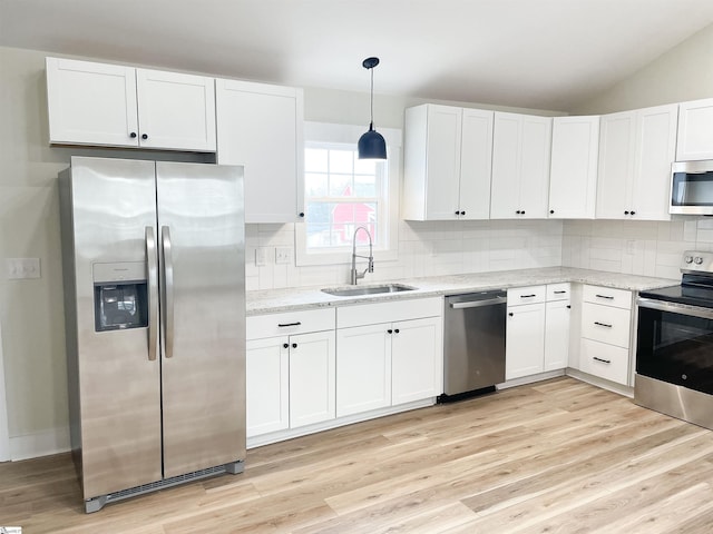 kitchen featuring stainless steel appliances, sink, pendant lighting, and white cabinets