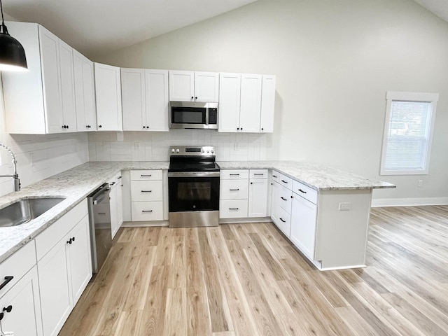 kitchen with sink, appliances with stainless steel finishes, white cabinetry, hanging light fixtures, and kitchen peninsula