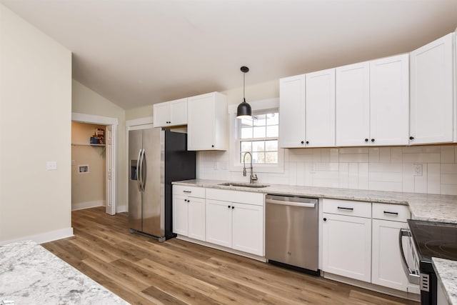 kitchen with white cabinetry, sink, decorative light fixtures, and appliances with stainless steel finishes