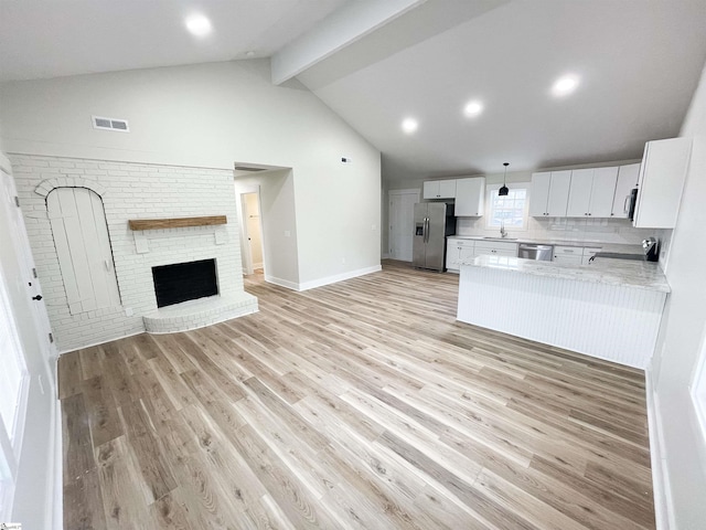 kitchen featuring white cabinetry, hanging light fixtures, light hardwood / wood-style floors, kitchen peninsula, and stainless steel appliances