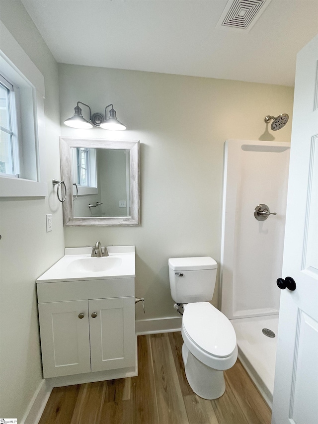 bathroom with vanity, wood-type flooring, toilet, and walk in shower