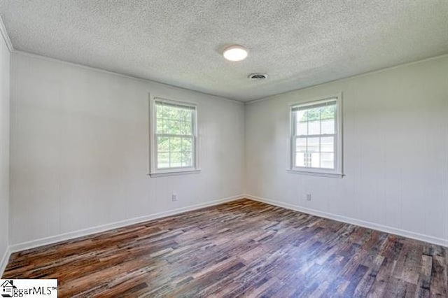 unfurnished room with dark hardwood / wood-style flooring and a textured ceiling