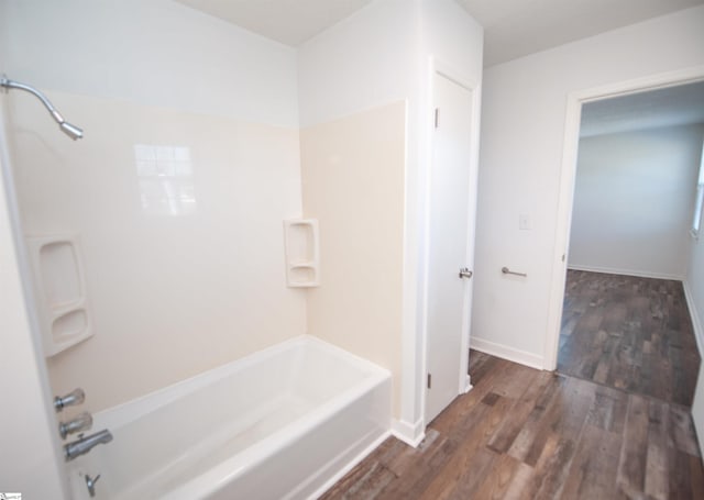 bathroom featuring wood-type flooring and bathtub / shower combination