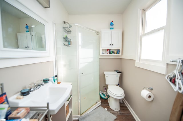 bathroom with a shower with door, vanity, hardwood / wood-style floors, and toilet