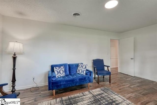 sitting room featuring wood-type flooring and a textured ceiling