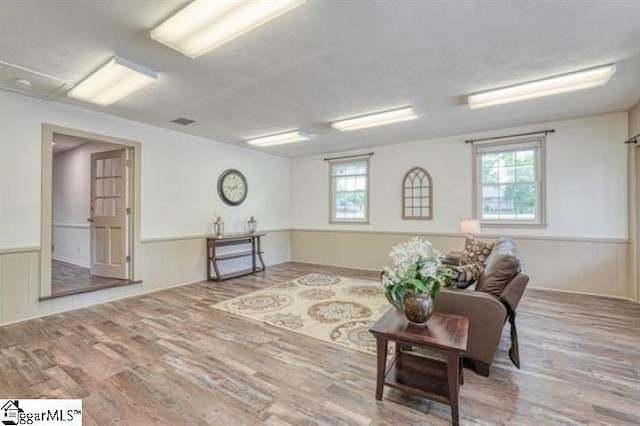 sitting room with plenty of natural light and hardwood / wood-style floors