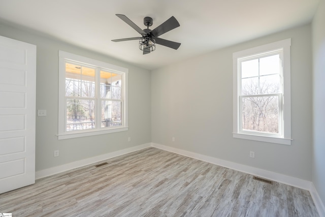 unfurnished room with a wealth of natural light, ceiling fan, and light hardwood / wood-style flooring