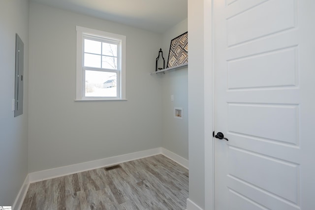 washroom with hookup for a washing machine, electric panel, and light hardwood / wood-style floors