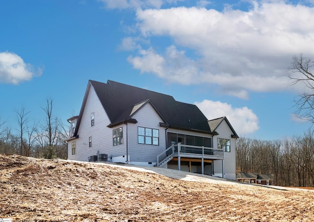 rear view of property with central AC and a sunroom