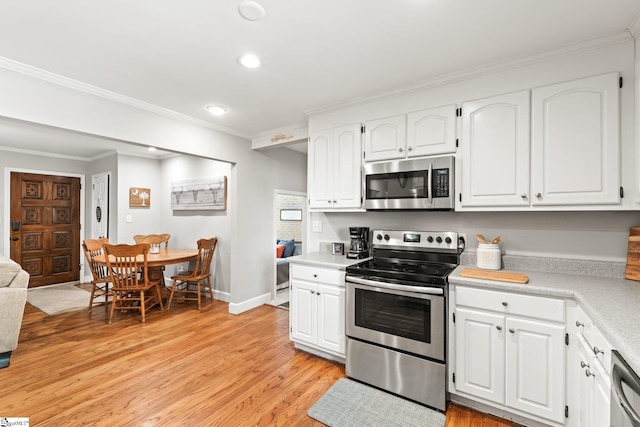 kitchen featuring crown molding, light hardwood / wood-style flooring, white cabinets, and appliances with stainless steel finishes