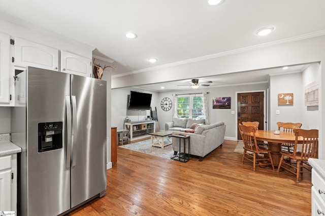 kitchen with white cabinetry, stainless steel fridge, ornamental molding, and light hardwood / wood-style flooring