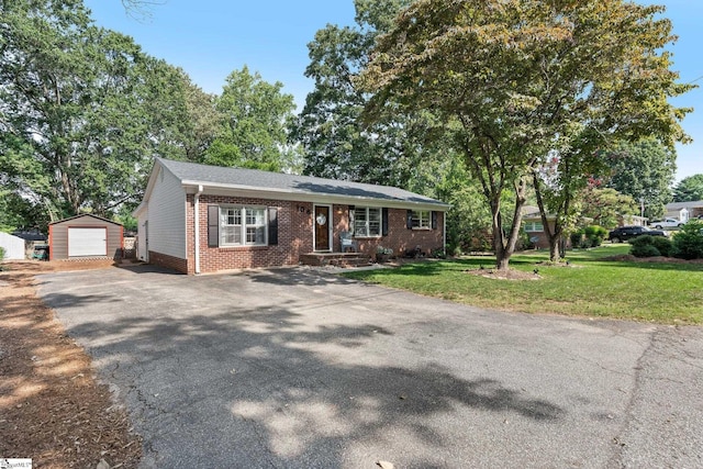 view of front facade featuring a garage, an outdoor structure, and a front yard