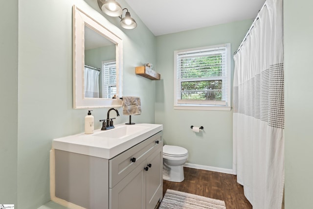 bathroom with hardwood / wood-style flooring, vanity, and toilet