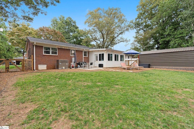 rear view of property featuring a yard and central air condition unit