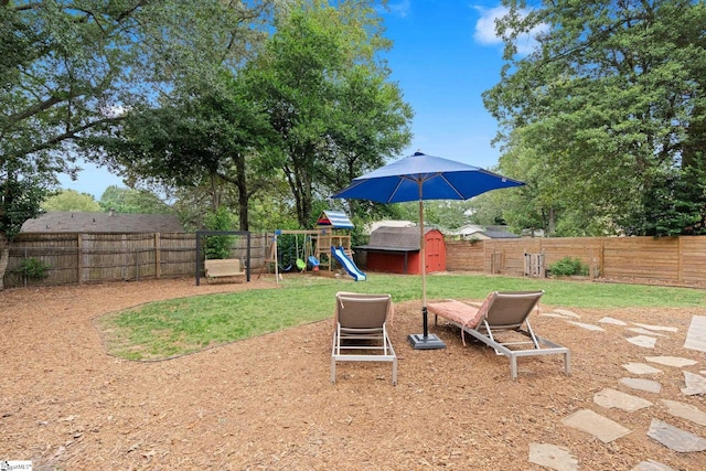 view of yard with a storage unit and a playground