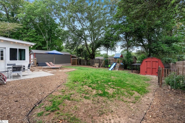 view of yard with a shed, a patio, and a playground