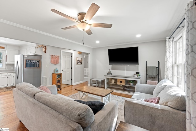 living room with crown molding, ceiling fan, and light hardwood / wood-style flooring