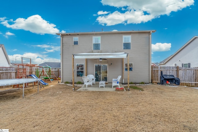 rear view of property with a patio, a yard, a playground, and a trampoline