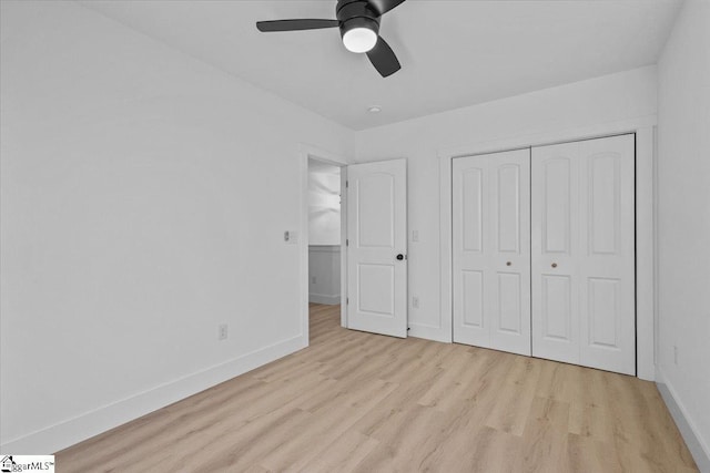 unfurnished bedroom featuring ceiling fan, a closet, and light wood-type flooring