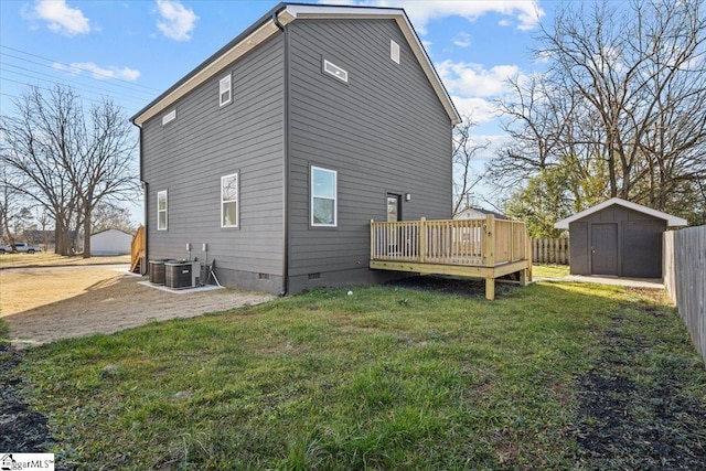 rear view of property featuring a storage shed, a lawn, central air condition unit, and a wooden deck