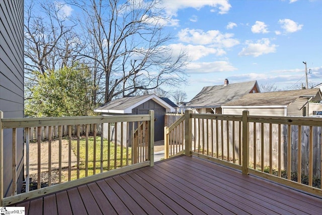 deck featuring a storage unit and a yard