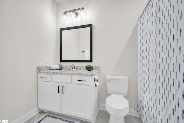 bathroom featuring vanity, toilet, and a shower with shower curtain