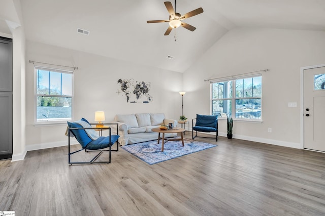 living room with ceiling fan, high vaulted ceiling, and light hardwood / wood-style flooring