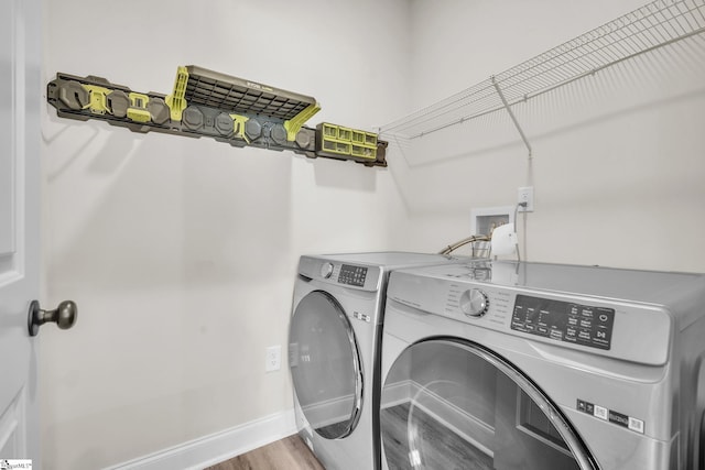 washroom featuring hardwood / wood-style flooring and washer and clothes dryer