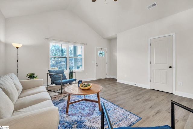 living room featuring hardwood / wood-style flooring, high vaulted ceiling, and ceiling fan