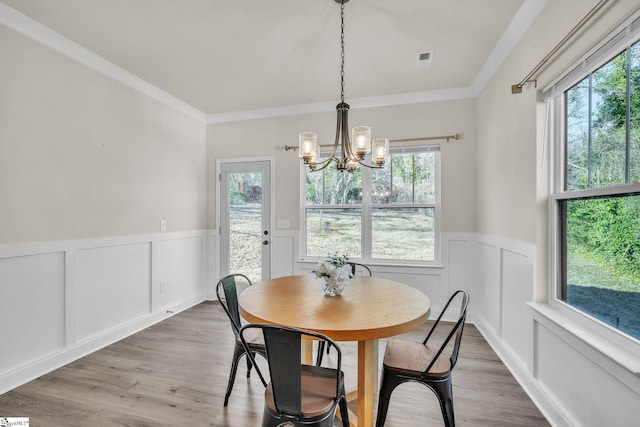 dining room featuring an inviting chandelier, ornamental molding, and wood-type flooring