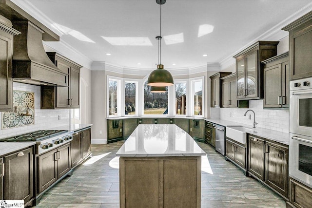 kitchen with sink, decorative light fixtures, a center island, custom range hood, and stainless steel appliances