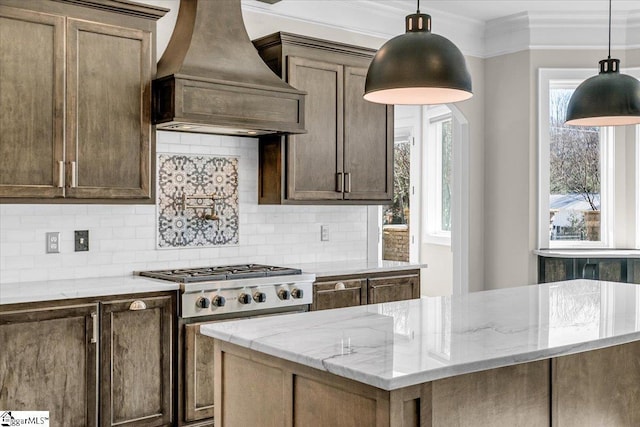 kitchen with premium range hood, light stone countertops, crown molding, and decorative backsplash