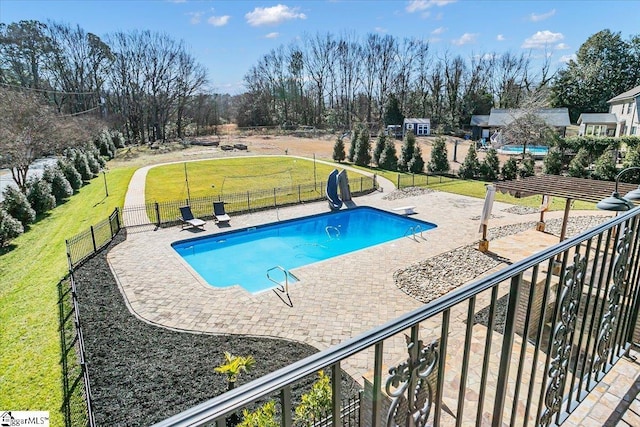 view of pool featuring a patio, a water slide, a yard, and a diving board