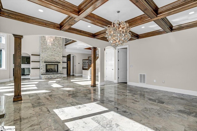 unfurnished living room featuring coffered ceiling, a stone fireplace, beamed ceiling, and an inviting chandelier