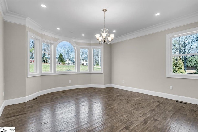 spare room with crown molding, dark hardwood / wood-style floors, and a chandelier