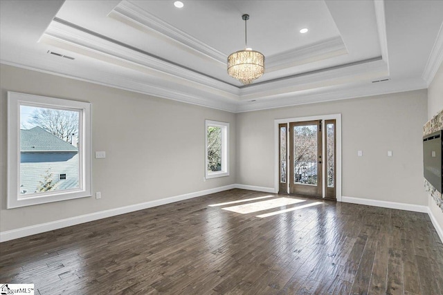 unfurnished living room featuring dark wood-type flooring, ornamental molding, a raised ceiling, and a chandelier