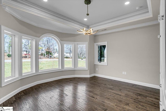 empty room featuring crown molding, dark hardwood / wood-style floors, and a raised ceiling